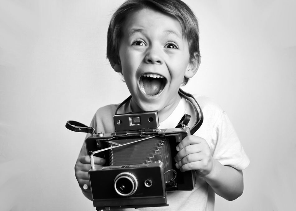 Blog IpsisPro crianca-segurando-uma-camera-antiga Dia Mundial da Fotografia – Como tudo começou? 
